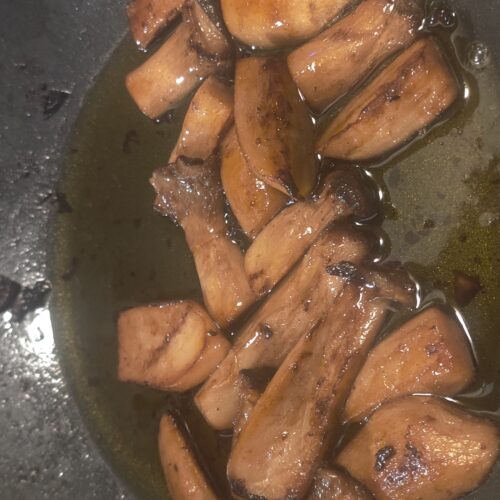 Fried Oyster Mushrooms soak in oil in a pan